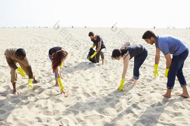 一群志愿者在海滩上<strong>清理垃圾</strong>