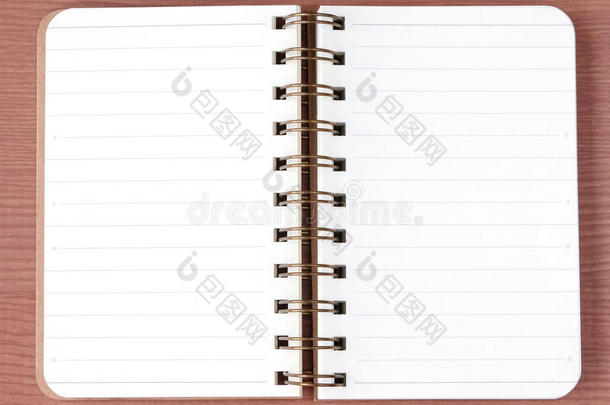 木桌背景上的空白笔记本，顶部视图