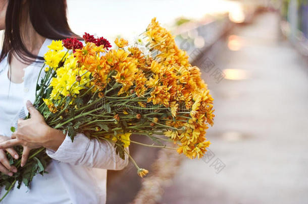 抽象的女人带着花束，手握鲜花，在模糊的街道上生机勃勃