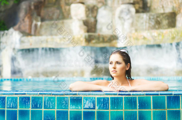 美丽的女人在夏天在游泳池里放松