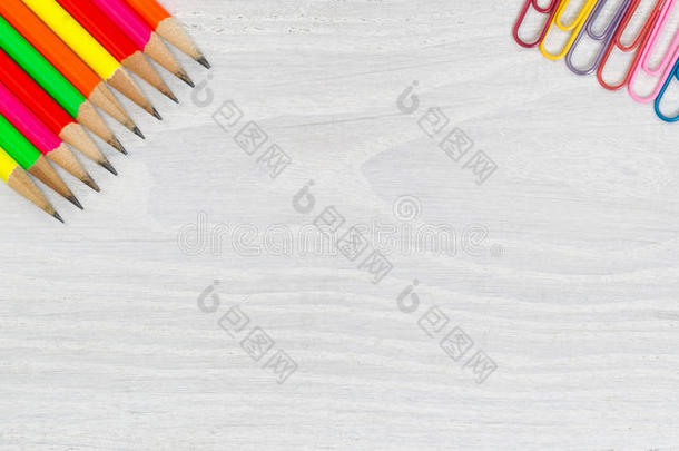 <strong>白色</strong>木制<strong>桌面上</strong>明亮的彩色铅笔和回形针