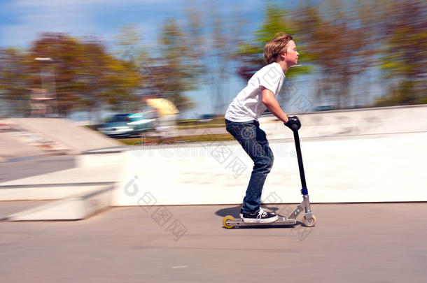 男孩骑着滑板车<strong>飞速</strong>行驶