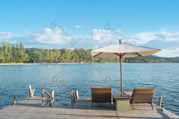 <strong>沙滩</strong>椅子和雨伞在木桌上，蓝天在<strong>普吉岛</strong>，泰国。