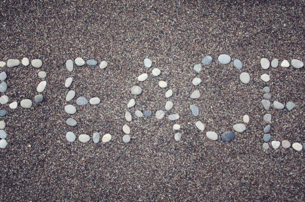 在沙滩上说“<strong>平安</strong>。 用鹅卵石写的。 老年照片。