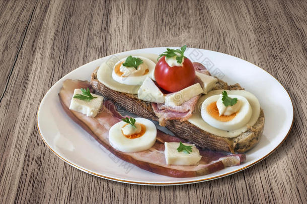 培根和鸡蛋三明治与额外的腹部培根碎肉提供在瓷盘设置在核桃木野餐桌