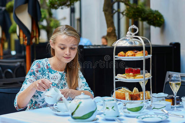 美丽的年轻女子享受下午茶