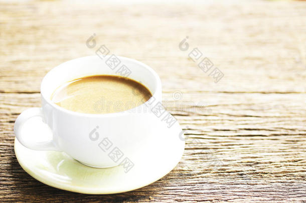 木制桌子上的白色杯子里的咖啡