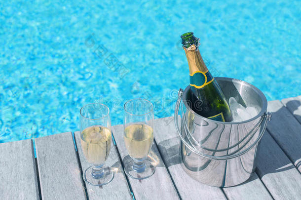 冰桶里的冷香槟瓶和两杯香槟在甲板上，桶里的瓶子和两杯香槟