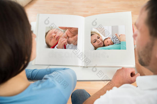 一对夫妇看着宝贝的相册