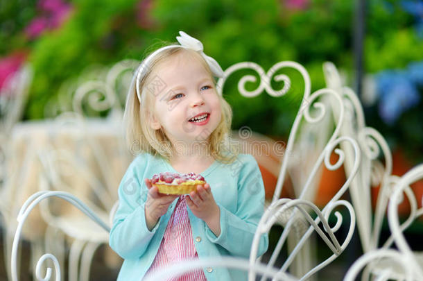 可爱的小女孩吃新鲜草莓蛋糕