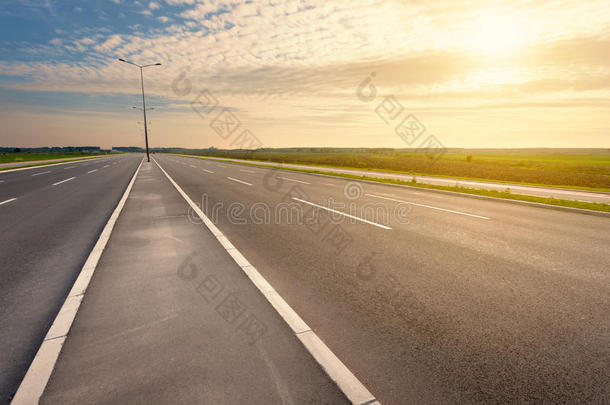 在一条空荡荡的高速公路上朝夕阳行驶