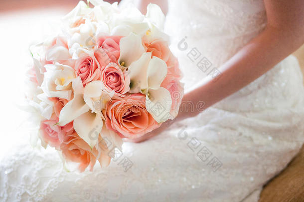 新娘带着橙色和粉红色的婚礼花束