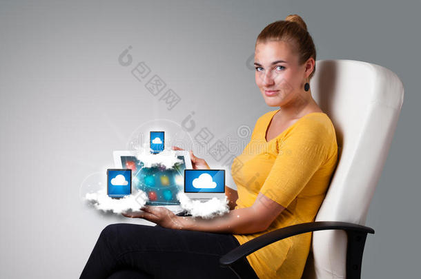 一个年轻的女人在云端拿着装有现代设备的平板电脑