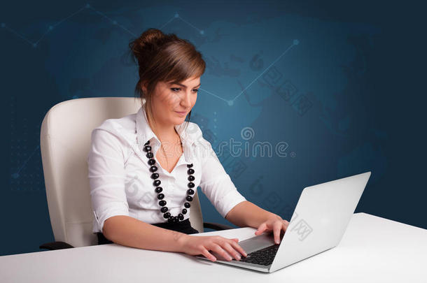 年轻女子<strong>坐在</strong>办公桌<strong>前</strong>用笔记本<strong>电脑</strong>打字