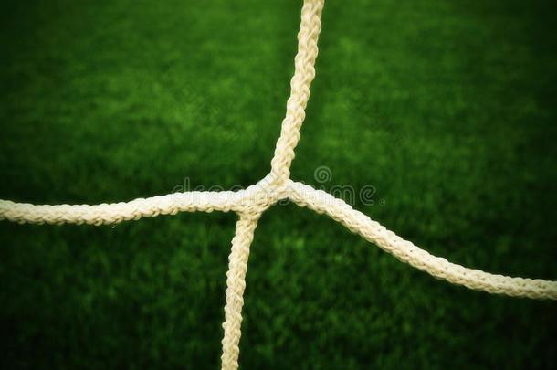 详细的交叉足球网，足球足球在球门网与塑料草在足球操场的背景