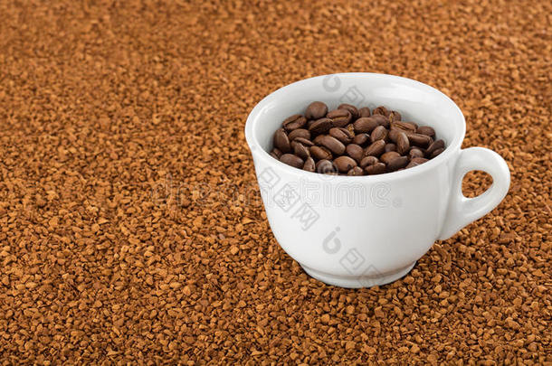 咖啡杯在速溶咖啡颗粒床上。