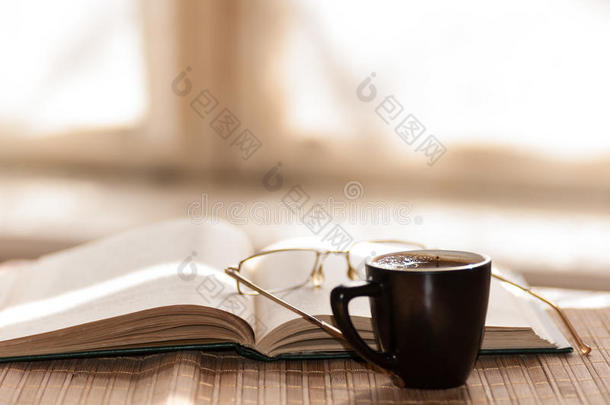 一杯咖啡，站在一本书旁边