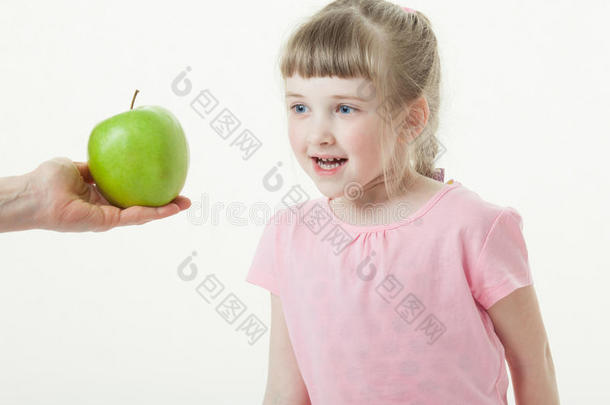 大人的手给漂亮的小女孩一个绿色的苹果
