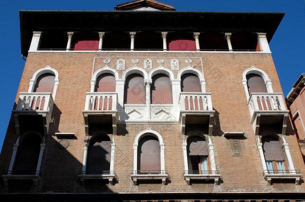 威尼斯三臂四个阳台的历史建筑立面。