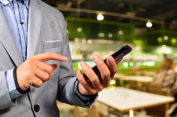 商人在餐厅或<strong>美食广场</strong>使用移动智能手机