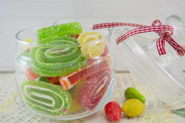 五颜六色的果冻卷在一个罐子里，放在一张折叠的桌子上