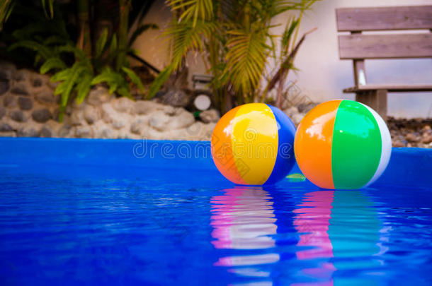 五颜六色的沙滩球漂浮在游泳池里