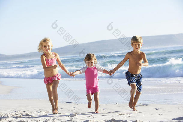 一群穿着<strong>泳装</strong>沿着<strong>海滩</strong>跑步的孩子