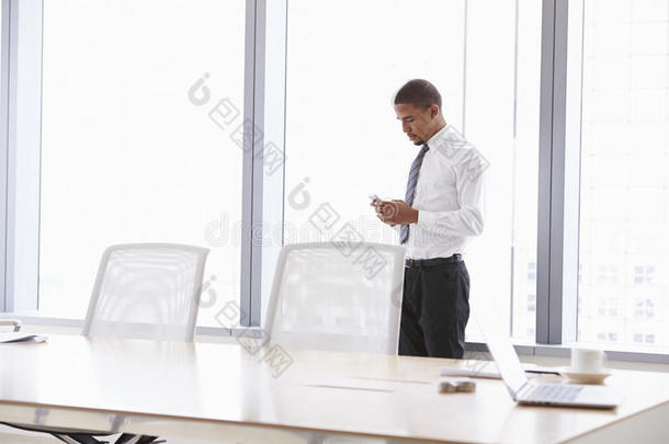 会议室里手机上的商人