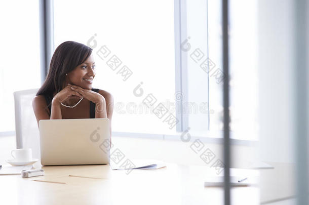 女商人在会议室桌子上用笔记本电脑工作