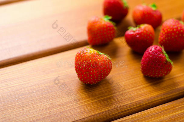 木制桌子上新鲜成熟的红色草莓