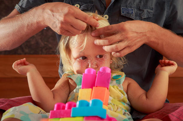女孩玩玩具建造师父亲刷她的头发特写