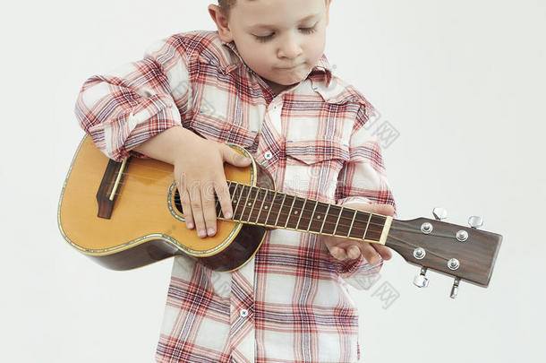 带吉他的有趣的男孩。乡村男孩演奏音乐