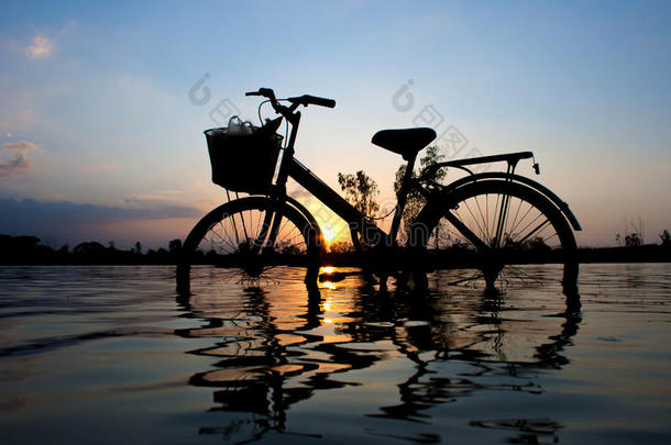 夕阳下站着的自行车剪影。