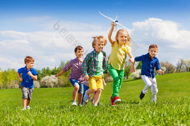 一群带着白色飞机的快乐奔跑的孩子