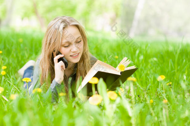 女学生躺在草地上看书，在绿草地上聊天