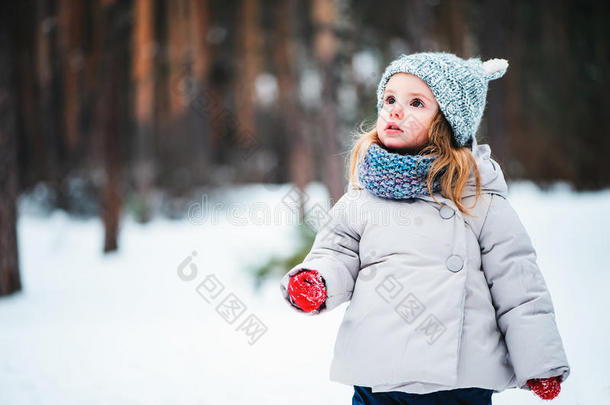 可爱的梦幻蹒跚学步的女孩在冬天的森林里散步