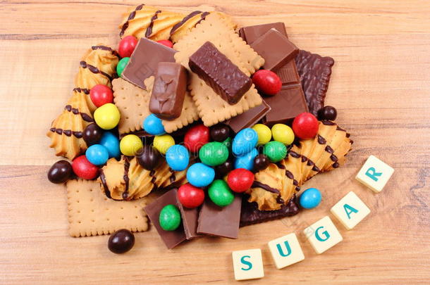很多糖果和文字糖在木制表面，不健康的食物