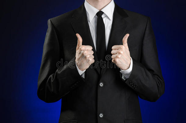 《商人与<strong>手势</strong>》主题：一名身穿黑色西装和白色衬衫的男子在深蓝色背景上竖起<strong>大拇指</strong>示意<strong>手势</strong>
