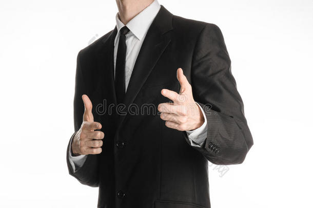 商人和手势主题：一个穿着黑色西装，戴着领带的男人，在圣的一个孤立的白色背景上，你的手上有一个标志