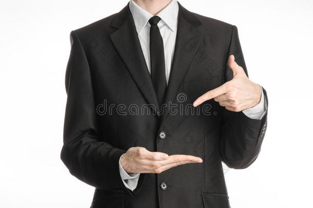 商人和手势主题：一个穿着黑色西装，打着领带的男人在白色的右手上显示左手食指