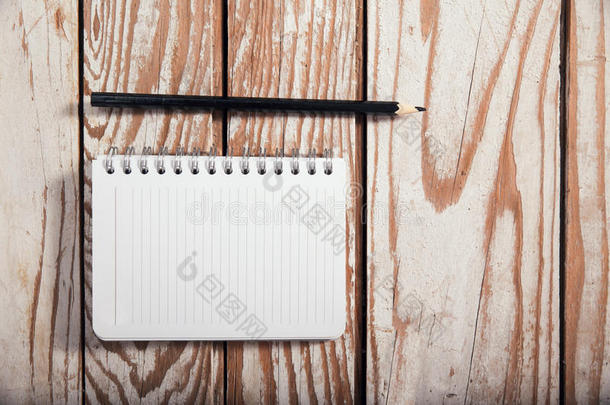 木制背景上的空白便签书纸和铅笔