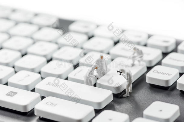 一群微型罪犯检查电脑键盘。 网络犯罪概念
