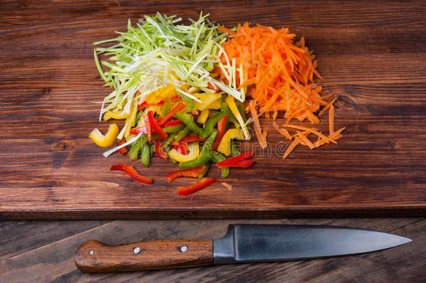 用刀在砧板上的五颜六色的蔬菜