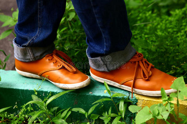 脚上穿着橙色舒适的鞋子走在城市街道的边境上