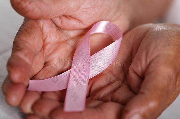 年长的女人手拿着粉红色的乳腺<strong>癌</strong>意识丝带