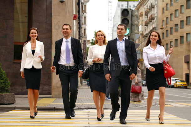 五个成功的商人穿过城市的街道