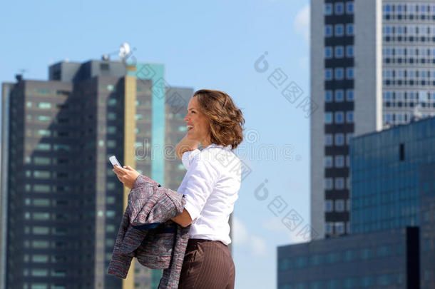 商务妇女带着手机在城市里散步