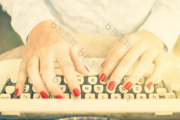 女孩在打字机上打字，老式照片效果