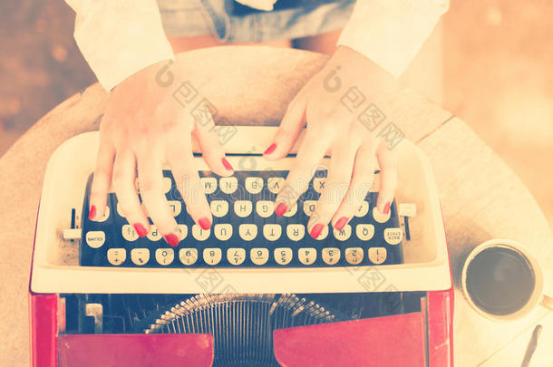 女孩在桌子上打字在打字机上，老式的照片效果
