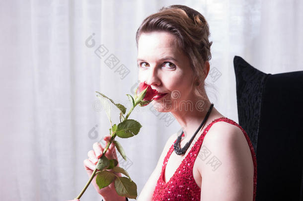 穿红裙子和玫瑰的有吸引力的女人